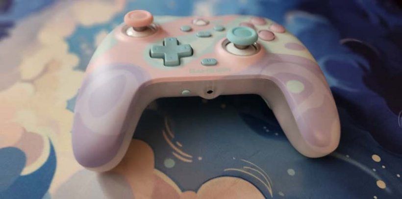 a pastel coloured controller laying flat on a pastel coloured mousepad