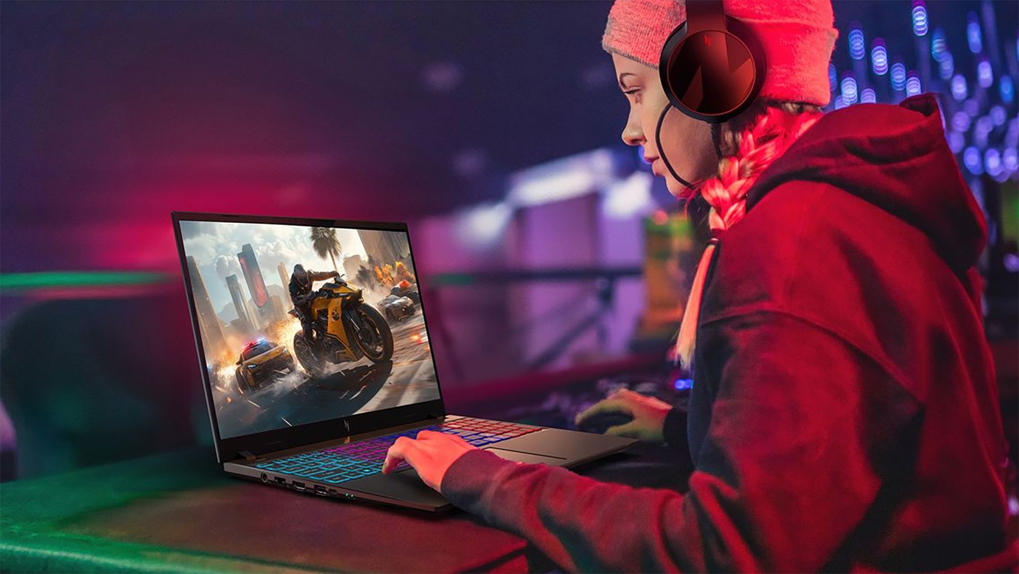 A girl in a hoodie playing a game on an Acer Nitro V 16S AI gaming laptop.